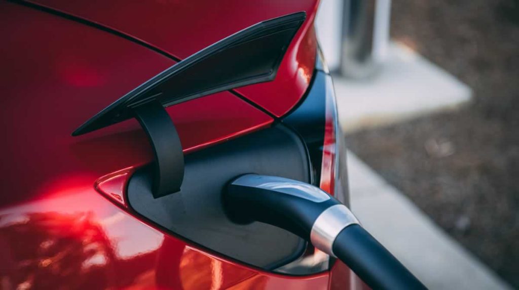 red car being charged with an EV electric vehiclecharger